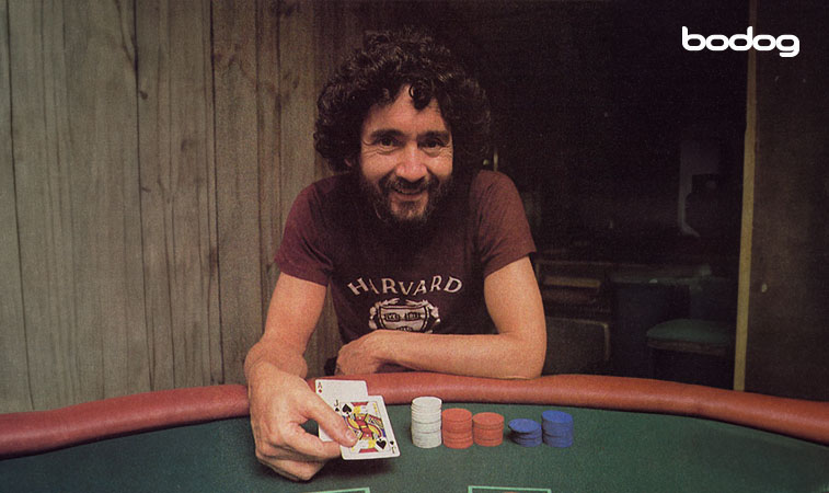 Ken Uston sosteniendo 2 cartas en una mesa con fichas