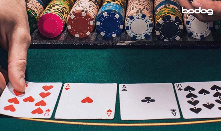 Dealer abrindo as cartas comunitárias no poker e fichas ao fundo