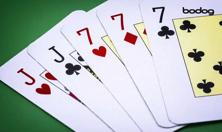 un trío de 7 en una mano de poker